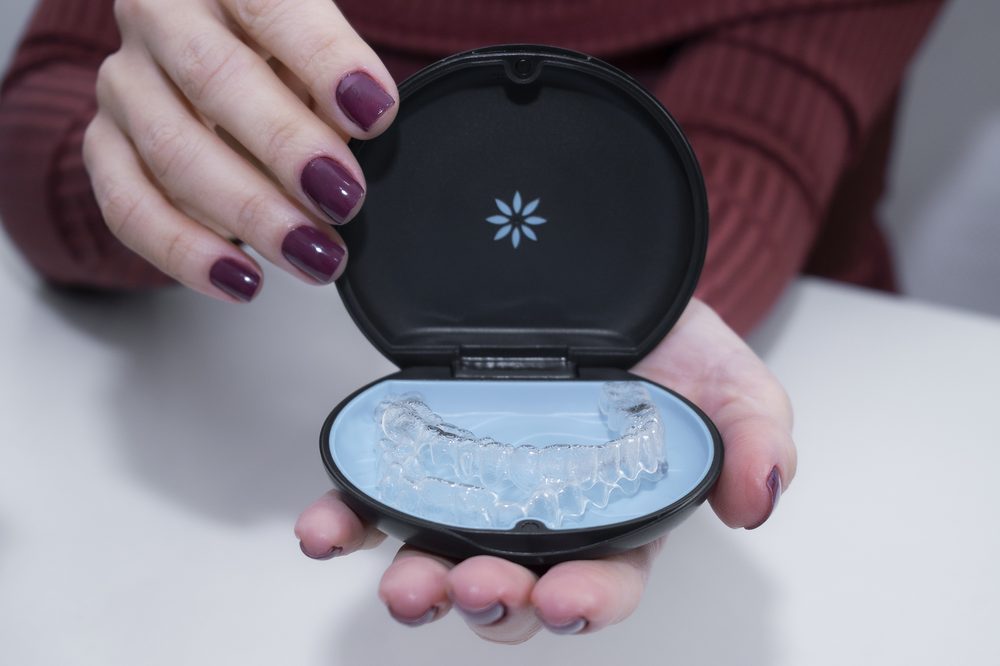 Estojo de alinhador Invisalign aberto, mostrando o dispositivo transparente
